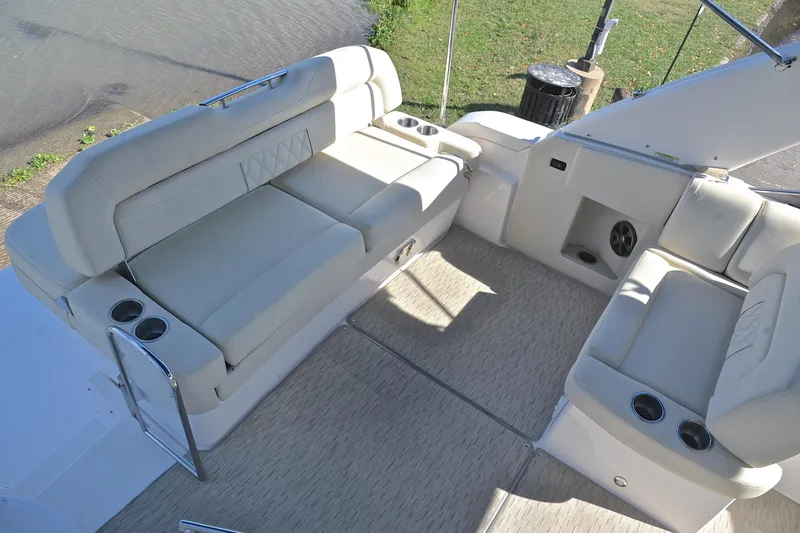 Slide: The Image of 2018 Regal 33 Express boat interior with beige seating and cup holders. - 25
