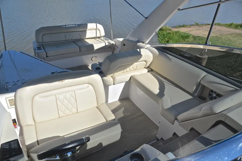 Slide: The Image of 2018 Regal 33 Express boat interior with luxurious beige seating and scenic water view. - 26