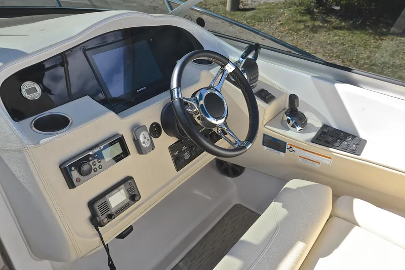 Slide: The Image of 2018 Regal 33 Express boat helm with steering wheel and navigation controls. - 30