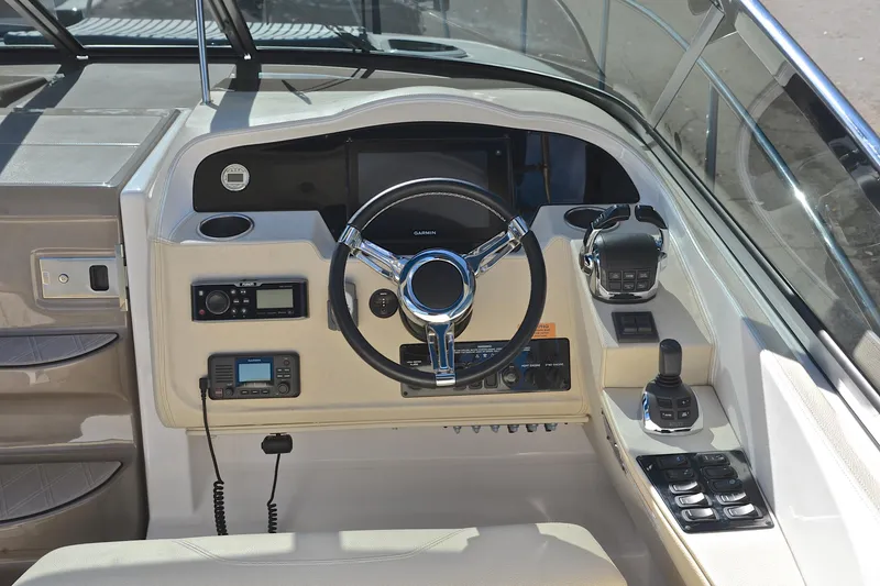 Slide: The Image of 2018 Regal 33 Express boat helm with steering wheel and navigation controls. - 31