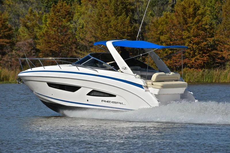 Slide: The Image of 2018 Regal 33 Express boat cruising on a lake with scenic autumn trees. - 4