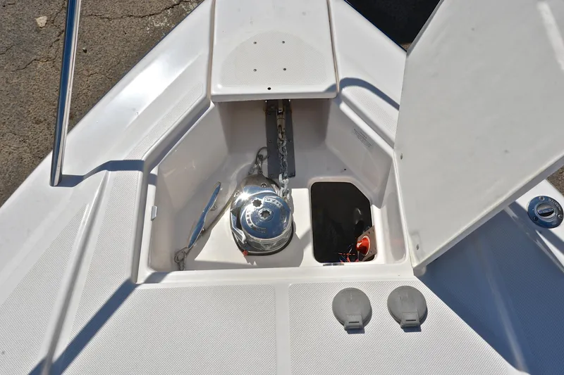 Slide: The Image of 2018 Regal 33 Express boat anchor compartment with open hatch and visible winch. - 41