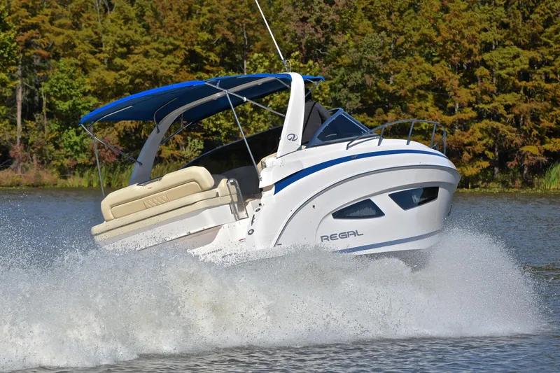 Slide: The Image of 2018 Regal 33 Express boat cruising on a lake with trees in the background. - 5