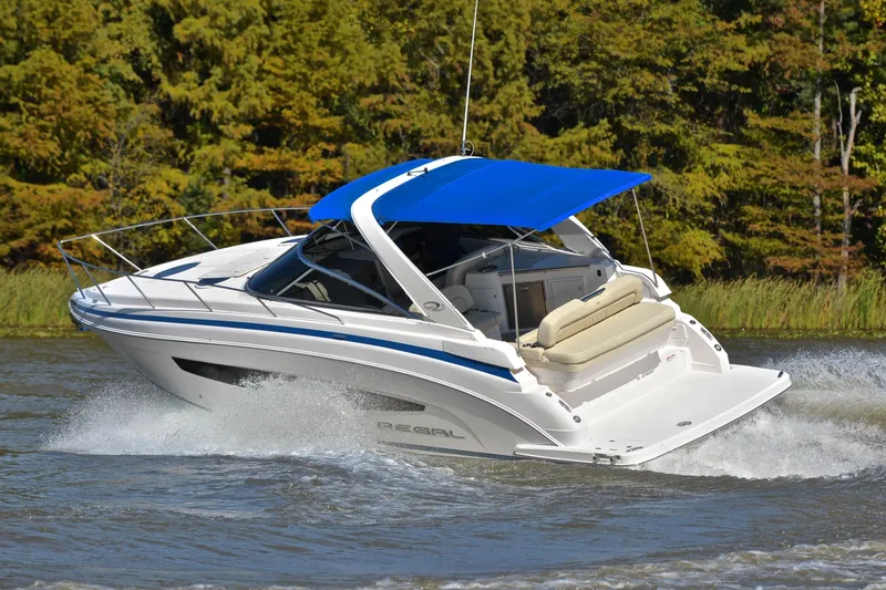 Slide: The Image of 2018 Regal 33 Express boat cruising on a lake with a blue canopy. - 7
