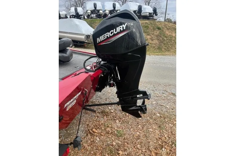 Slide: The Image of 2024 Tracker Pro Team 175 TXW boat with Mercury outboard motor, parked outdoors. - 16