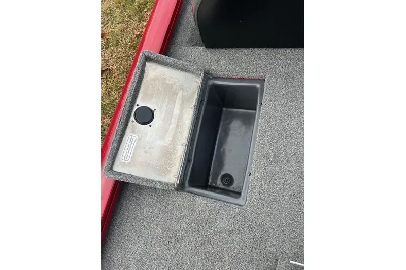 Slide: The Image of 2024 Tracker Pro Team 175 TXW storage compartment with open lid on carpeted deck. - 18