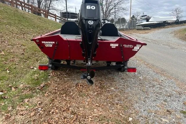 Slide: The Image of 2024 Tracker Pro Team 175 TXW boat on a trailer, parked on a gravel path. - 4