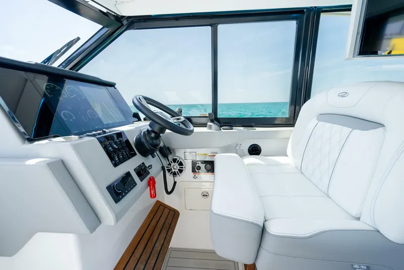 Slide: The Image of 2022 Regal 36 Grande Coupe helm with modern controls and ocean view. - 11