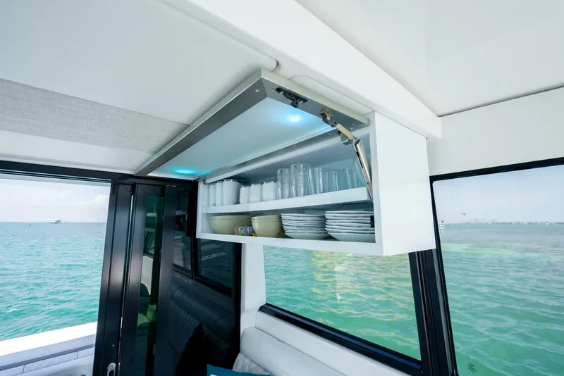 Slide: The Image of Interior of 2022 Regal 36 Grande Coupe yacht with open cabinet displaying dishes and glasses. - 13