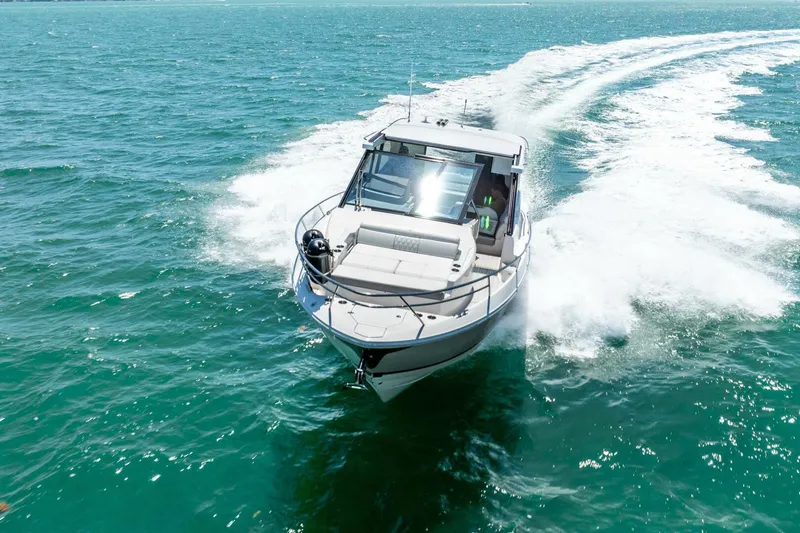 Slide: The Image of 2022 Regal 36 Grande Coupe cruising on open water, creating a dynamic wake. - 26