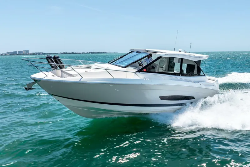 Slide: The Image of 2022 Regal 36 Grande Coupe cruising on open water under clear skies. - 28