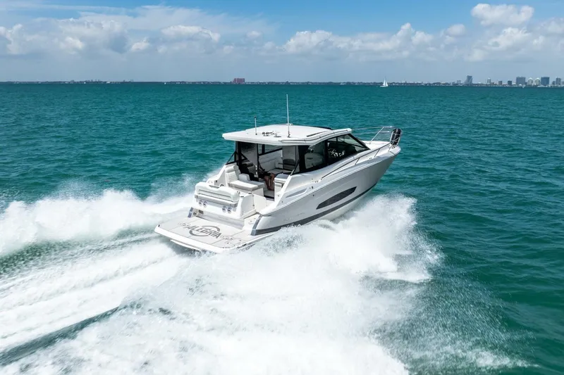 Slide: The Image of 2022 Regal 36 Grande Coupe cruising on open water under a clear blue sky. - 30