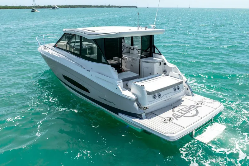 Slide: The Image of 2022 Regal 36 Grande Coupe yacht cruising on turquoise waters. - 31