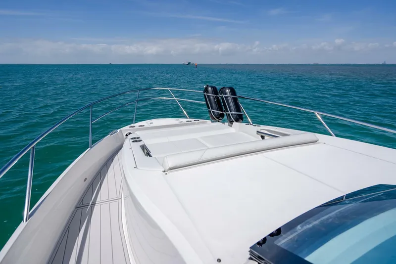 Slide: The Image of 2022 Regal 36 Grande Coupe yacht cruising on open sea under clear blue sky. - 4