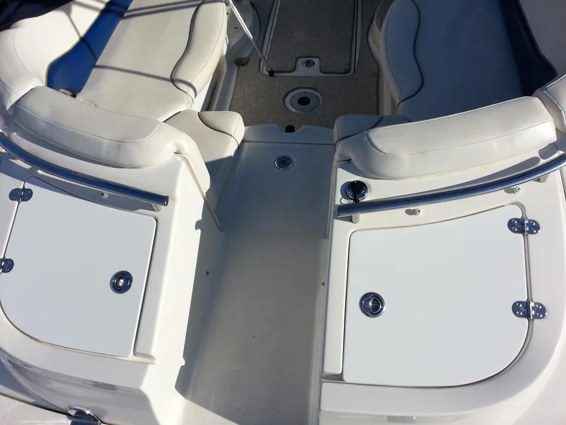 Slide: The Image of 2006 Monterey 233 Explorer boat interior with white seating and storage compartments. - 11