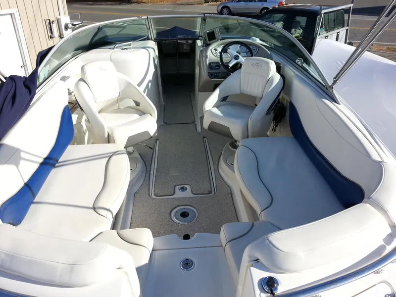 Slide: The Image of 2006 Monterey 233 Explorer boat interior with white seating and steering console. - 13