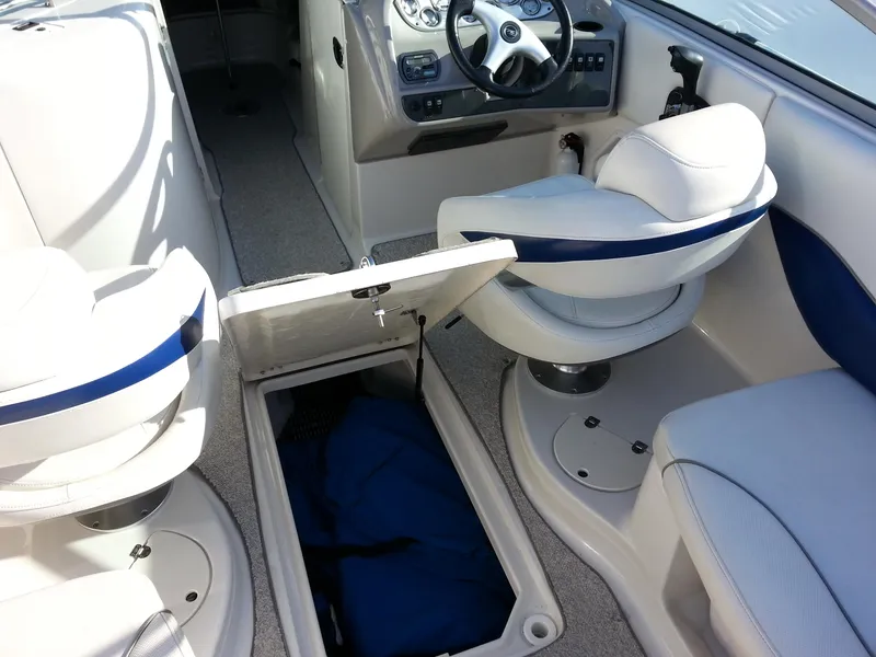 Slide: The Image of 2006 Monterey 233 Explorer boat interior with open storage compartment and white seating. - 20