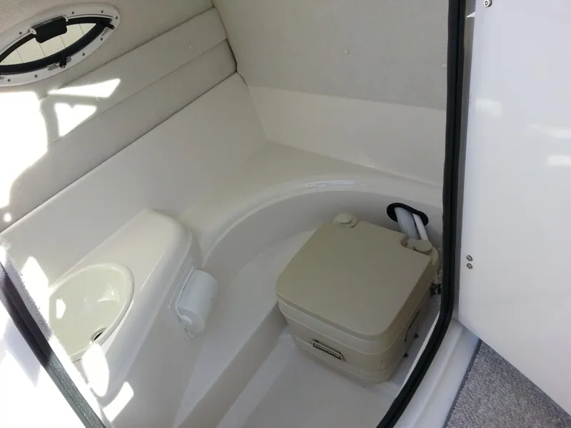 Slide: The Image of 2006 Monterey 233 Explorer boat interior with compact toilet and small window. - 25