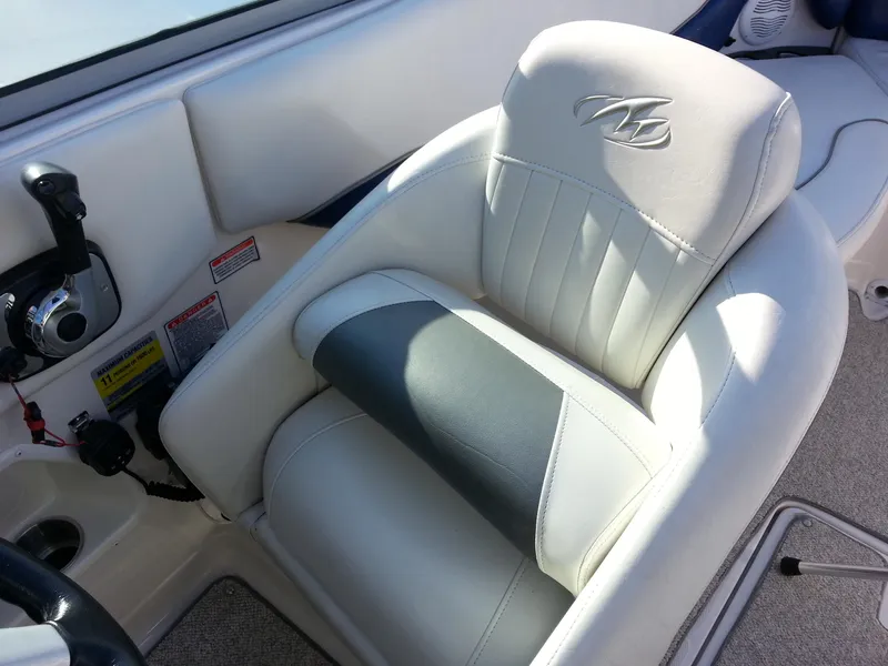 Slide: The Image of Captain's seat in 2006 Monterey 233 Explorer boat, featuring white and gray upholstery. - 33