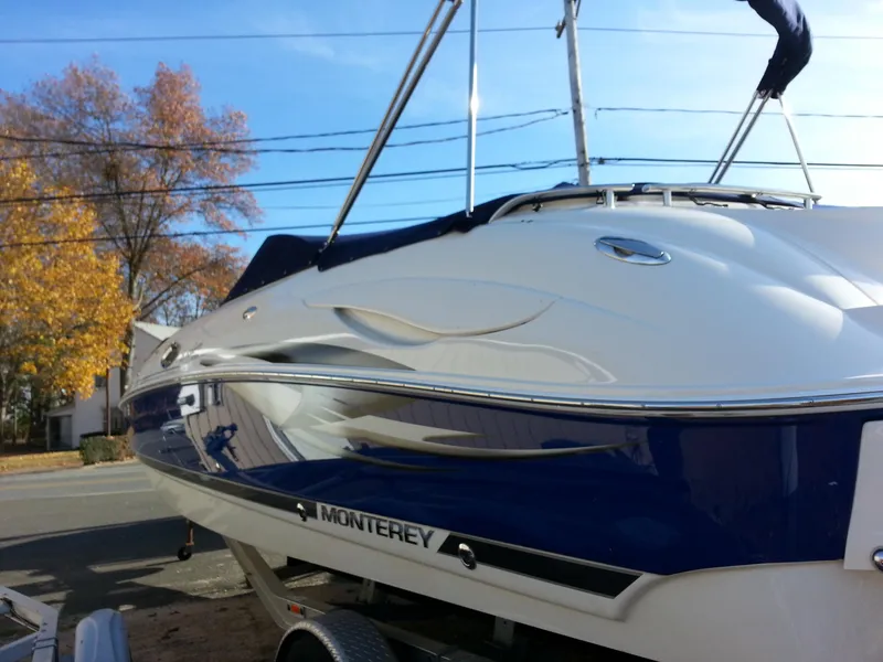 Slide: The Image of 2006 Monterey 233 Explorer boat on trailer, blue and white design, autumn trees in background. - 36