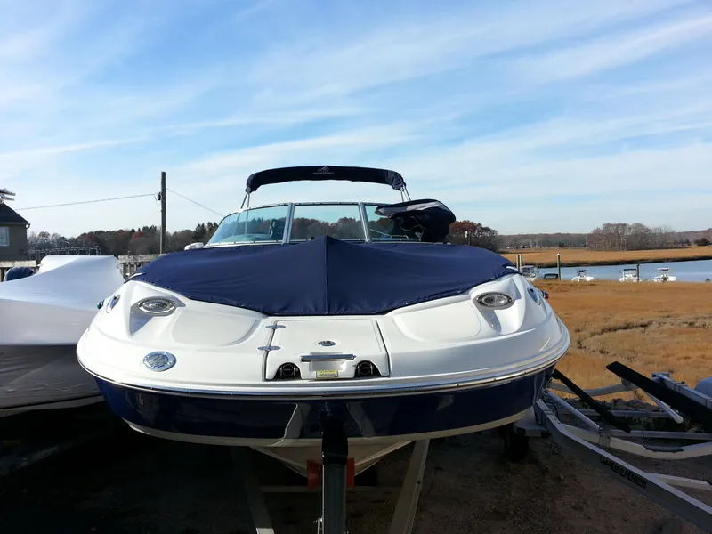 Slide: The Image of 2006 Monterey 233 Explorer boat docked near a serene waterfront. - 6