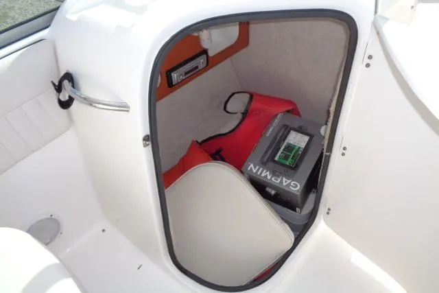 Slide: The Image of 2005 Robalo R227 Dual Console storage compartment with Garmin device and life jacket. - 14