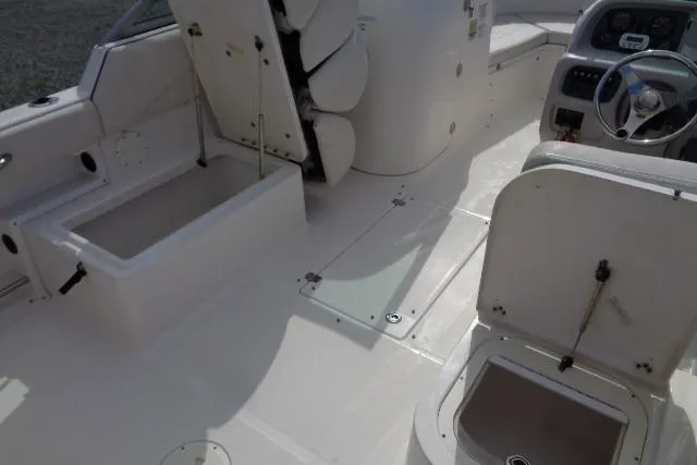 Slide: The Image of 2005 Robalo R227 Dual Console boat interior with open storage compartments and steering console. - 16