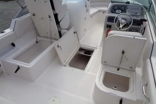 Slide: The Image of 2005 Robalo R227 Dual Console boat interior with open storage compartments and steering wheel. - 17