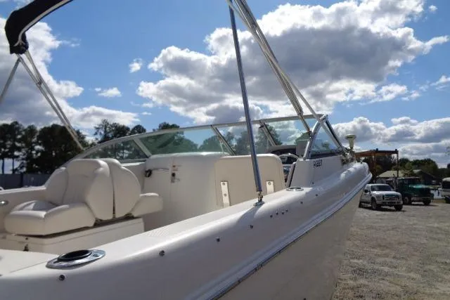 Slide: The Image of 2005 Robalo R227 Dual Console boat with white seating under a partly cloudy sky. - 6