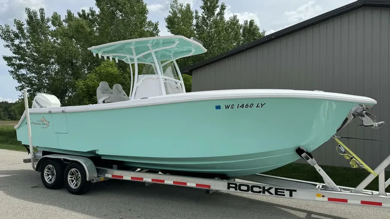 Slide: The Image of 2022 Streamline Center Console boat on trailer, light blue, parked outdoors. - 1