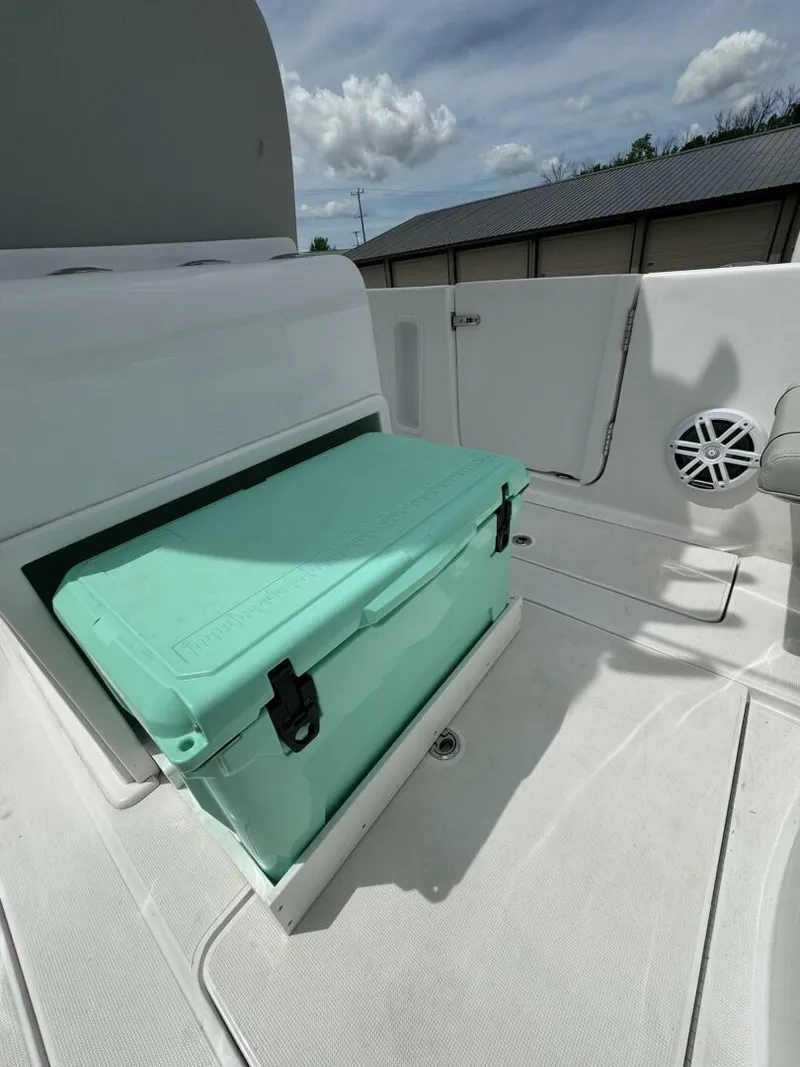 Slide: The Image of 2022 Streamline Center Console boat with a teal cooler on deck under a cloudy sky. - 12