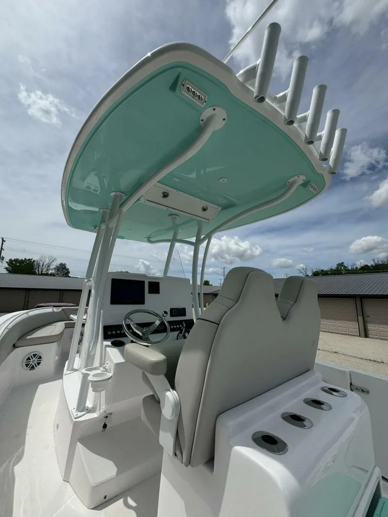 Slide: The Image of 2022 Streamline Center Console boat with modern helm and rod holders under a blue sky. - 13