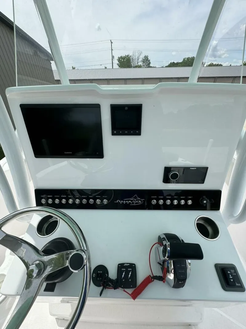 Slide: The Image of 2022 Streamline Center Console boat dashboard with steering wheel, screens, and controls. - 15
