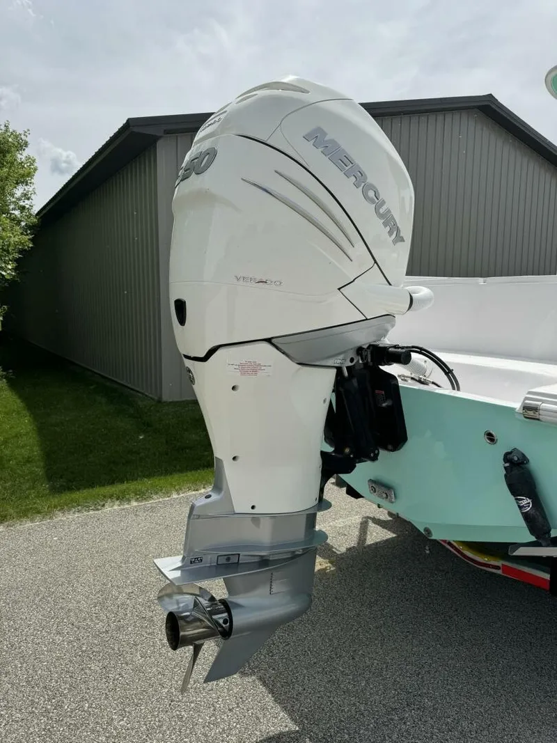 Slide: The Image of 2022 Streamline Center Console boat with a powerful outboard motor, parked outdoors. - 5