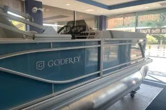 Slide: The Image of 2026 Godfrey Sweetwater 2086 CSE pontoon boat displayed in showroom. - 2