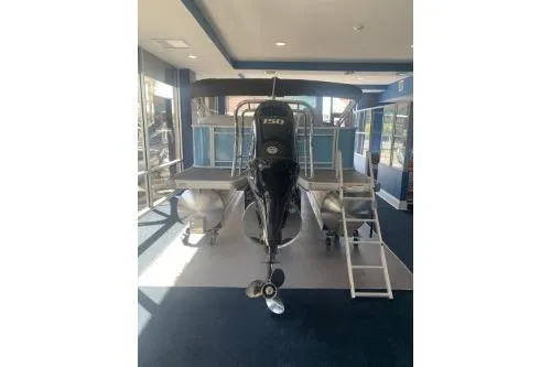 Slide: The Image of 2026 Godfrey Sweetwater 2086 CSE pontoon boat displayed indoors with a powerful outboard motor. - 3