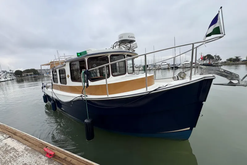 Slide: The Image of 2016 Ranger Tugs R-27 boat docked in a marina, overcast sky. - 1