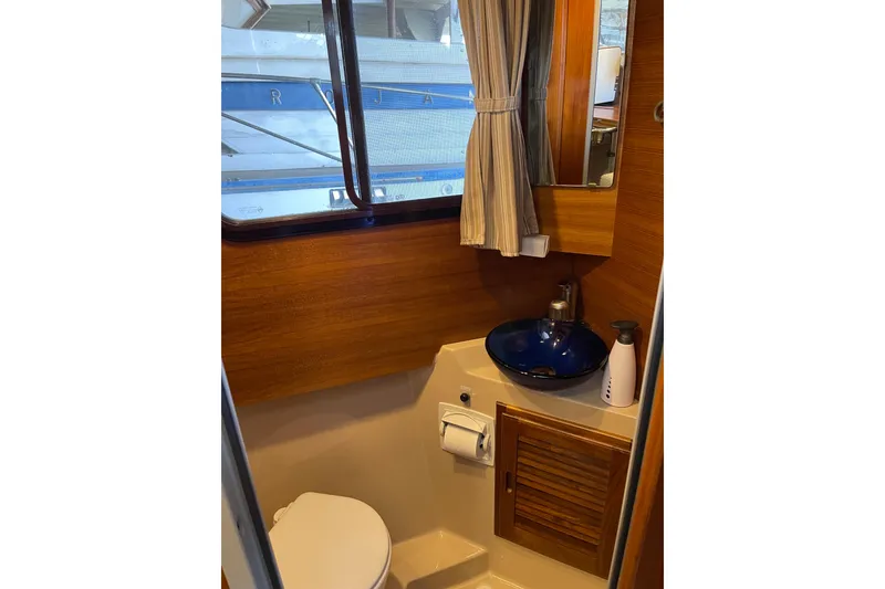 Slide: The Image of 2016 Ranger Tugs R-27 boat bathroom with wooden accents and blue sink. - 10