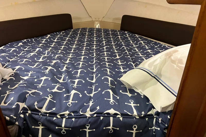 Slide: The Image of Cozy cabin bed in 2016 Ranger Tugs R-27 with nautical anchor-themed bedding. - 12