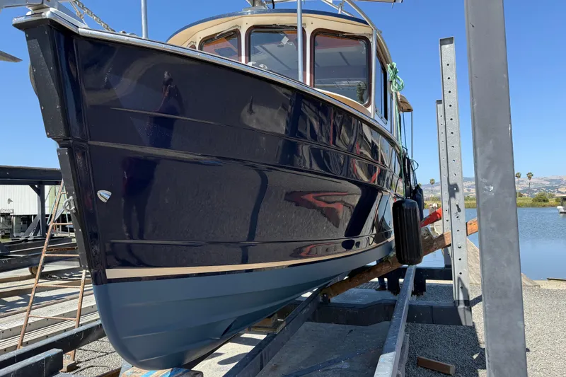 Slide: The Image of 2016 Ranger Tugs R-27 boat on a lift, showcasing sleek design and craftsmanship. - 14