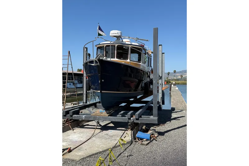 Slide: The Image of 2016 Ranger Tugs R-27 boat on a lift at a marina dock. - 15