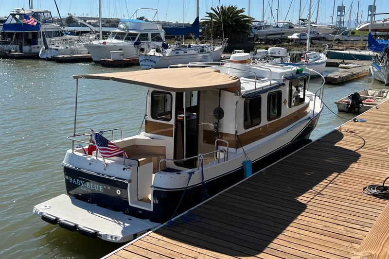 Slide: The Image of 2016 Ranger Tugs R-27 boat docked at marina with American flag. - 16