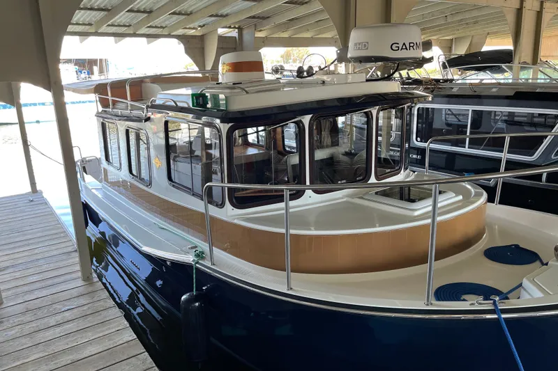 Slide: The Image of 2016 Ranger Tugs R-27 boat docked under a covered marina. - 18