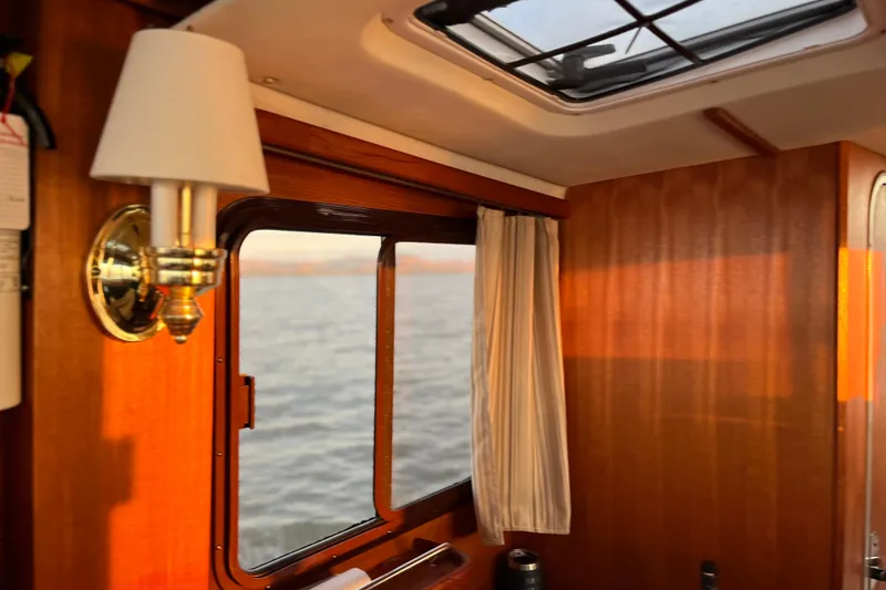 Slide: The Image of Interior of 2016 Ranger Tugs R-27 boat with wooden paneling and window view. - 27