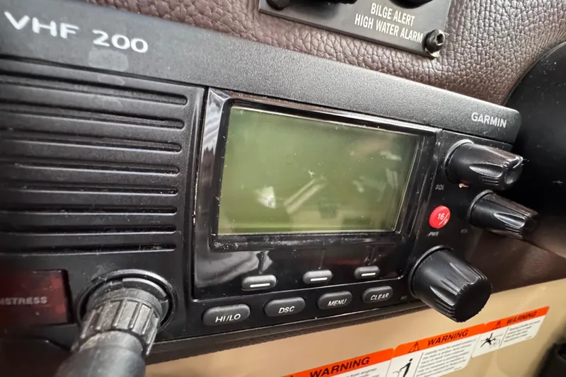 Slide: The Image of VHF 200 radio on 2016 Ranger Tugs R-27 boat dashboard, featuring Garmin controls. - 33