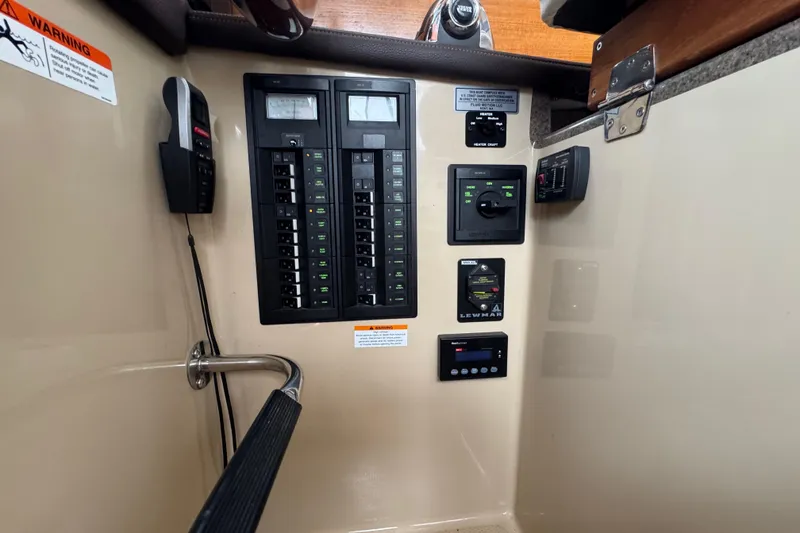 Slide: The Image of Control panel of a 2016 Ranger Tugs R-27 boat with various switches and indicators. - 49