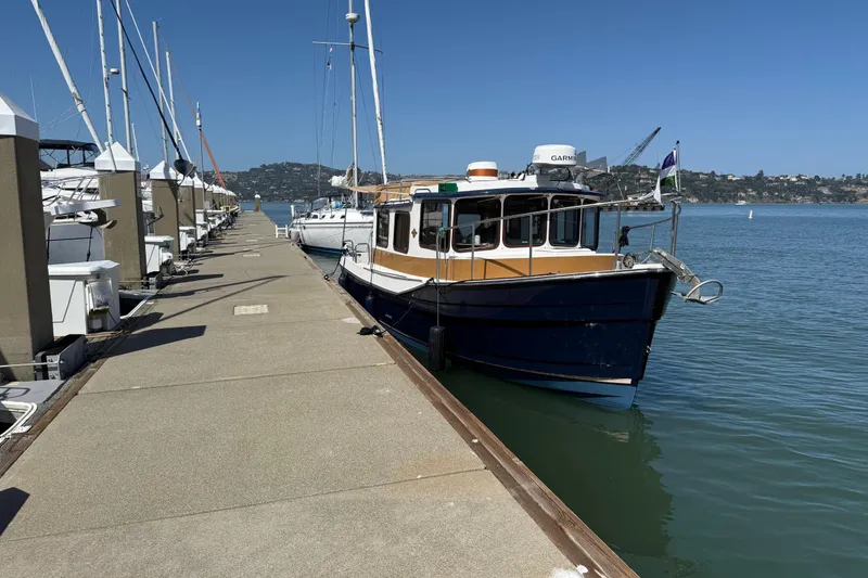 Slide: The Image of 2016 Ranger Tugs R-27 docked at a marina on a sunny day. - 5