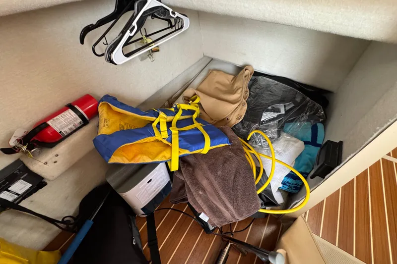 Slide: The Image of Storage area in 2016 Ranger Tugs R-27 with life jacket, fire extinguisher, and accessories. - 55