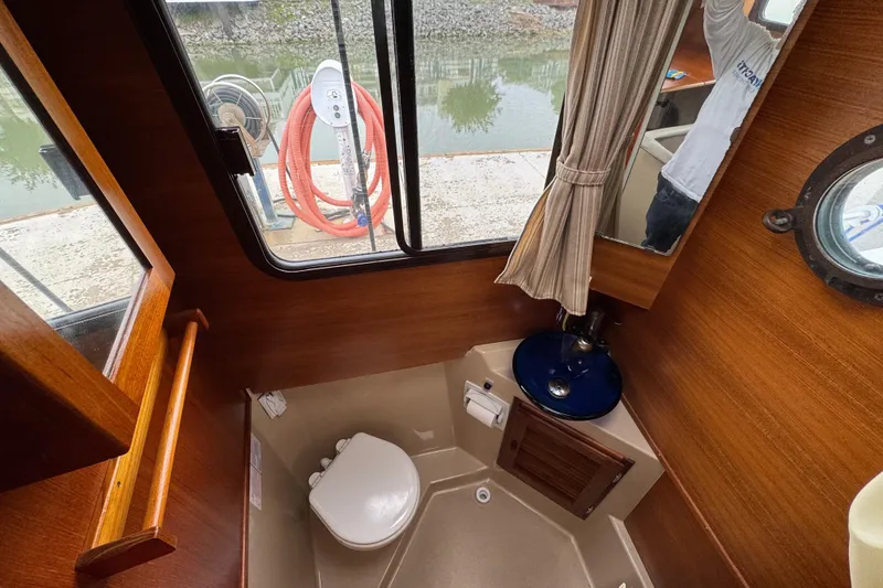 Slide: The Image of Interior of 2016 Ranger Tugs R-27 boat bathroom with window and sink. - 58