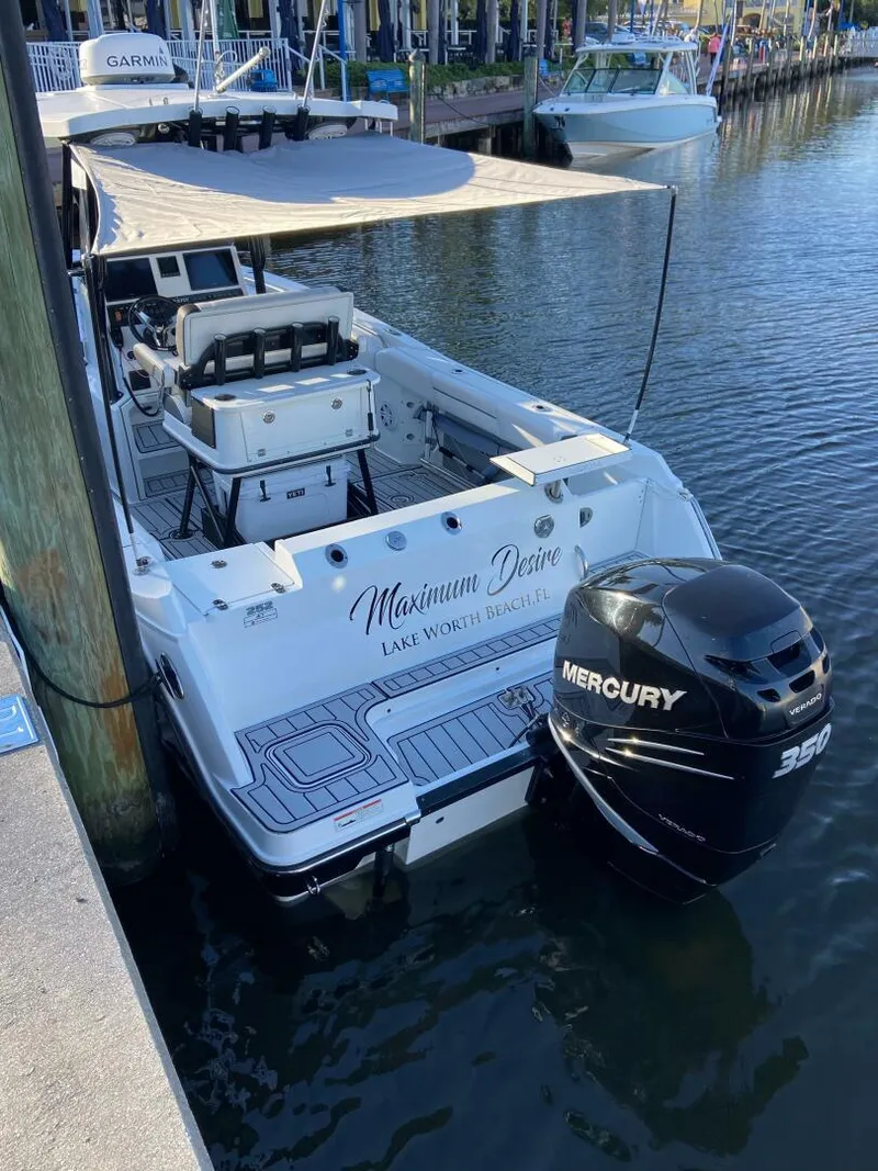 Slide: The Image of 2021 Blackfin 252 boat docked, featuring a Mercury 350 engine and shaded deck. - 3